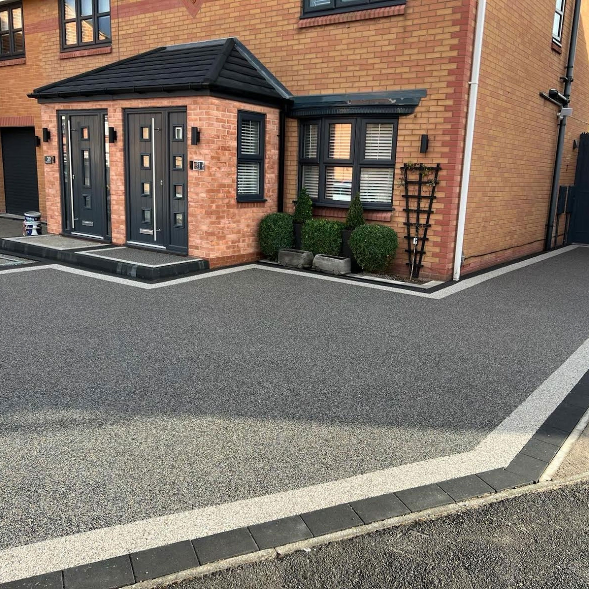 modern resin driveway with border outside new semi-detached house