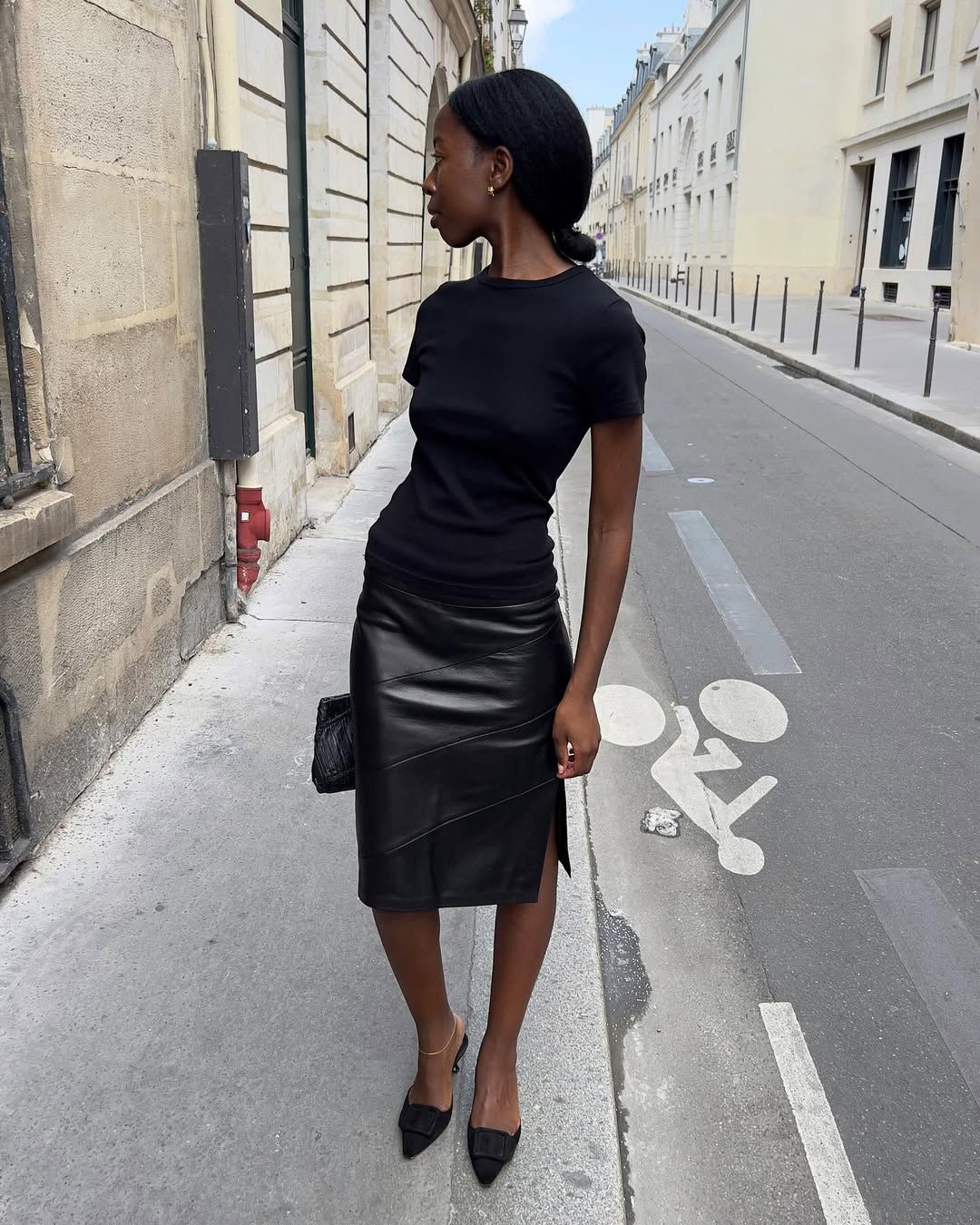 Woman wearing a black leather pencil skirt.