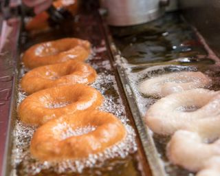 Preparation of fried donuts in a hot oil using a deep fryer