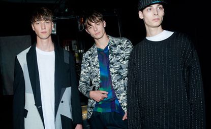 Three guys wearing Casely-Hayford S/S 2015 collection. The guy on the right is wearing a white t-shirt and jacket. The guy in the middle is wearing a colourful shirts with shades of blue and green with a jacket and the guy on the right is wearing a white t-shirt with a knitted jersey.