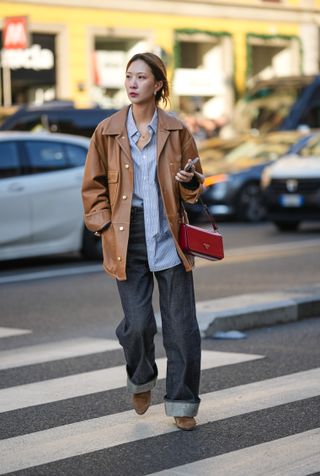 woman wearing button-down shirt, jacket, jeans, and cowboy boots