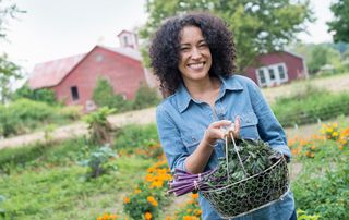 A woman gardening holding green leaves which are ideal for a menopause diet