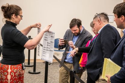 Leon County Supervisor of Elections employee, Holly Thompson, shows an original ballot and one remarked by the canvassing board to allow the ballot to be machine counted.