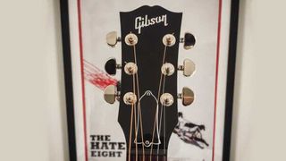 Gibson J-45 headstock with movie poster in the background