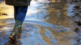 A person walking through water in wellies