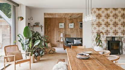 living space with dining table and wishbone dining chairs and a snug, a floor-to-ceiling tiled chimney breast with woodburner