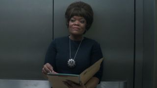 Yvette Nicole Brown holding a folder open and standing in an elevator in Endgame.