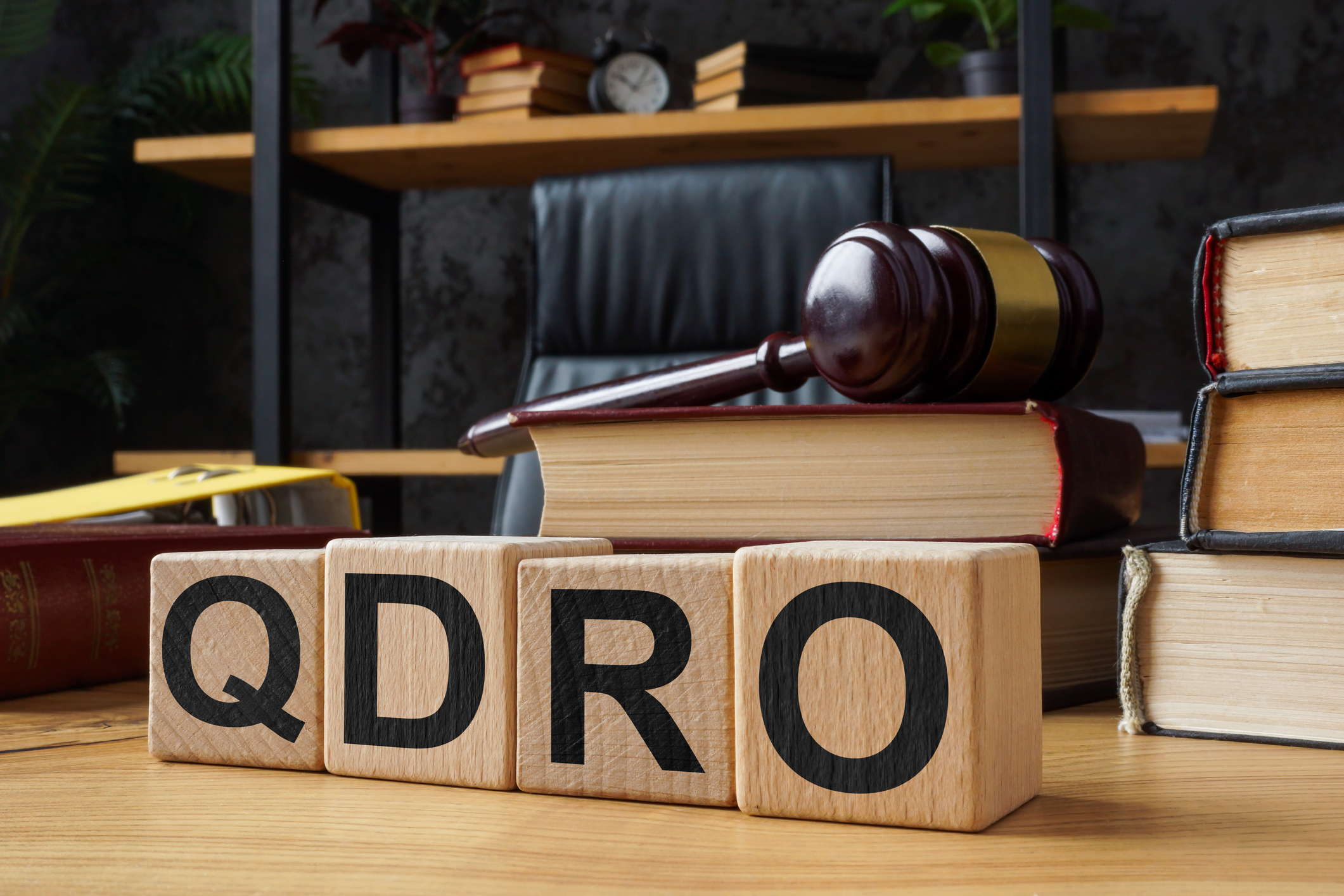 Table and wooden cubes with abbreviation QDRO Qualified Domestic Relations Order.
