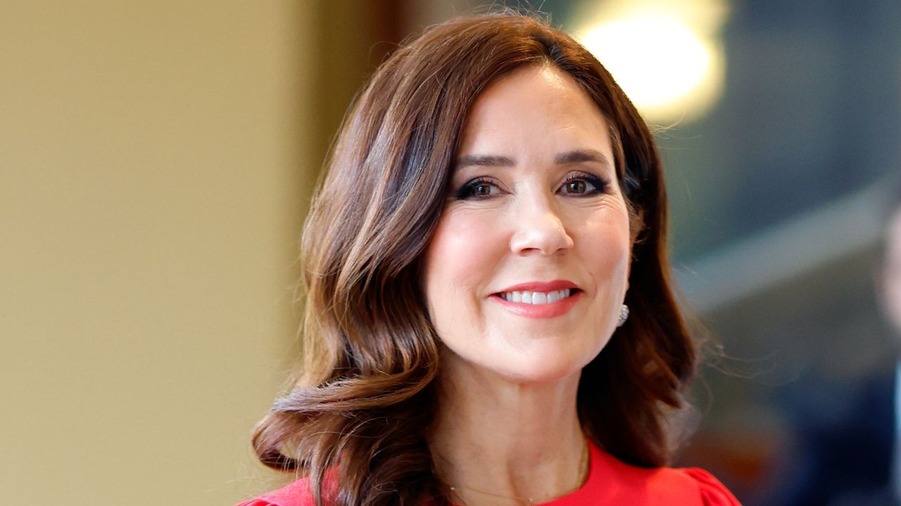 Crown Princess Mary of Denmark’s cherry red keyhole dress is stunning. Seen here she attends a reception at Buckingham Palace