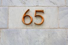 gold number 65 on a brick wall