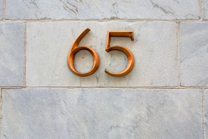 gold number 65 on a brick wall