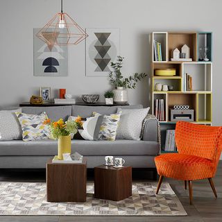 living room with grey wall and sofa set and orange armchair