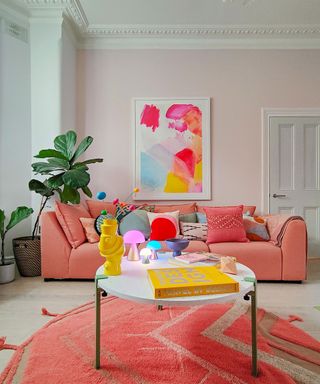 pink sofa in a pastel pink room with large rug