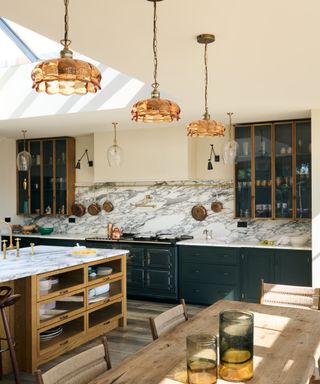 Marble kitchen with wooden cabinetry and glass-fronted upper cabinets