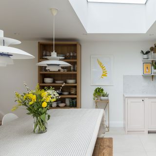 a basement with a dining table and a Louis Poulsen pendant light hanging overhead