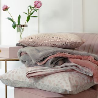 sofa chair with pink and white pillows and blanket