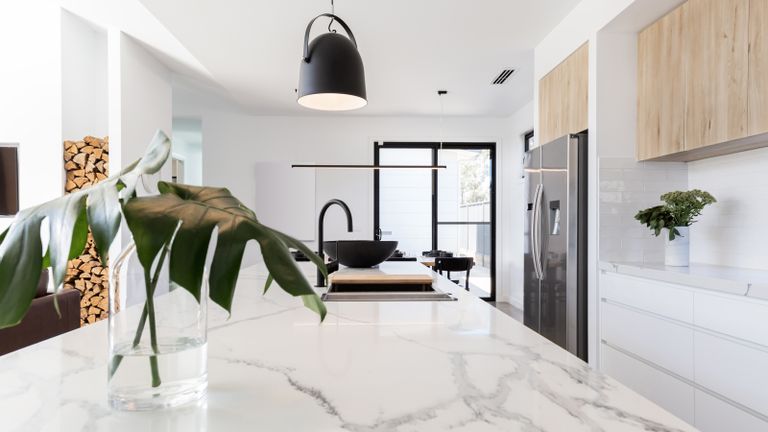 Kitchen marble bench close up with black hanging pendant 