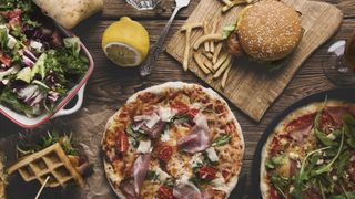 Burgers and pizzas on wooden table
