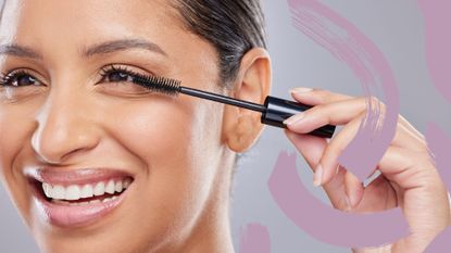 A woman applying mascara on bottom lashes smiling