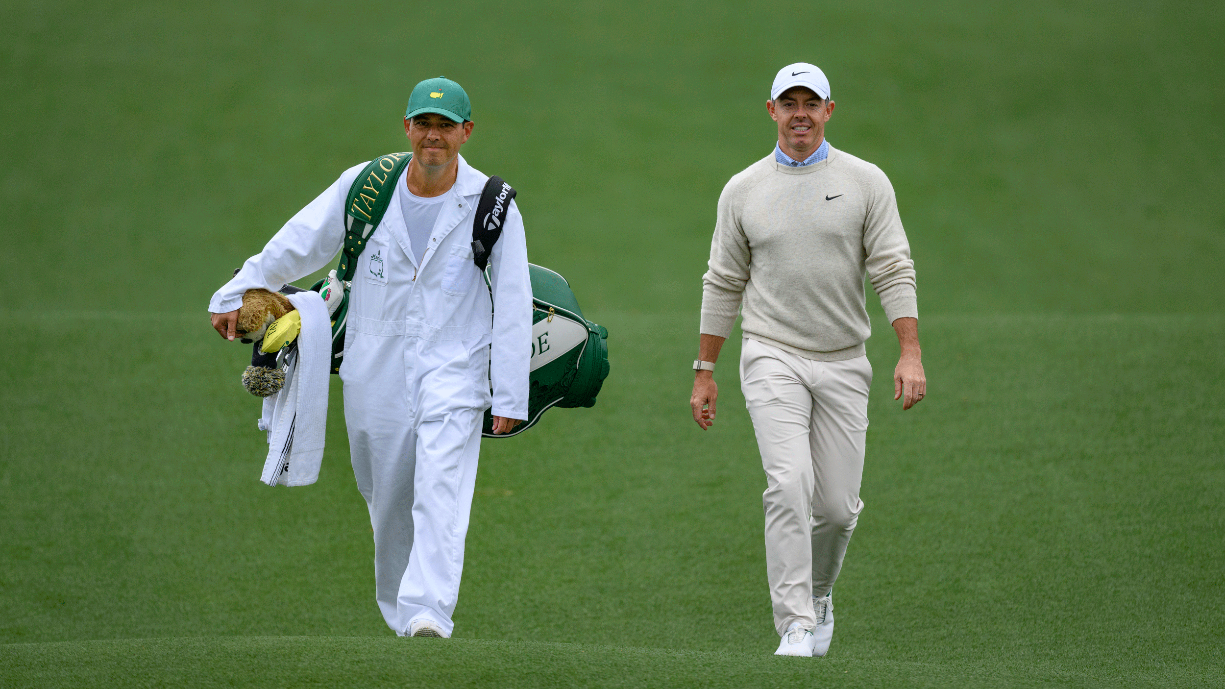 Rory McIlroy (right) and Harry Diamond walk down a fairway at Augusta National Golf Club during the 2026 Masters Tournament