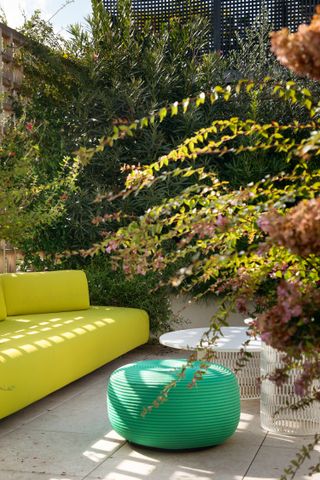 A backyard with pop colored furniture