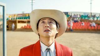 Steven Yeun as Ricky Park, looking up while performing for a crowd in Jordan Peele&#039;s Nope