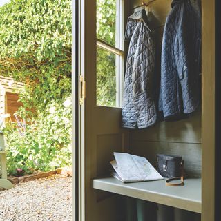 small bootroom area at rear of cottage, with coat hooks and a bench seat