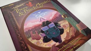 The Hobbit: There & Back Again box, which shows Bilbo Baggins from behind striding out of his front door, on a white surface