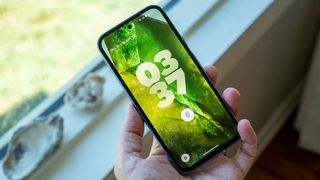 The lockscreen of the Google Pixel 8a with large, chunky clock numbers and a green theme