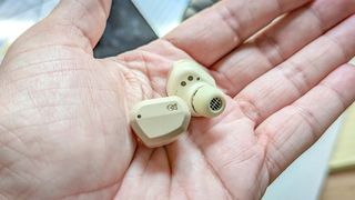 Campfire Audio Orbit earbuds in beige in palm of reviewer's hand