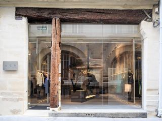 Housed within a historical Marais building, the store features an arched entry and a glass façade