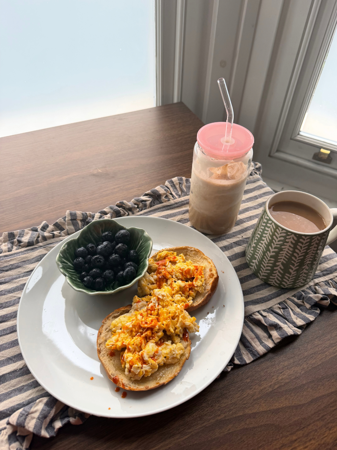 Breakfast served on a plate alongside a tea and iced drink