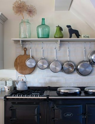 Aga in kitchen and display of hanging pans and open shelving