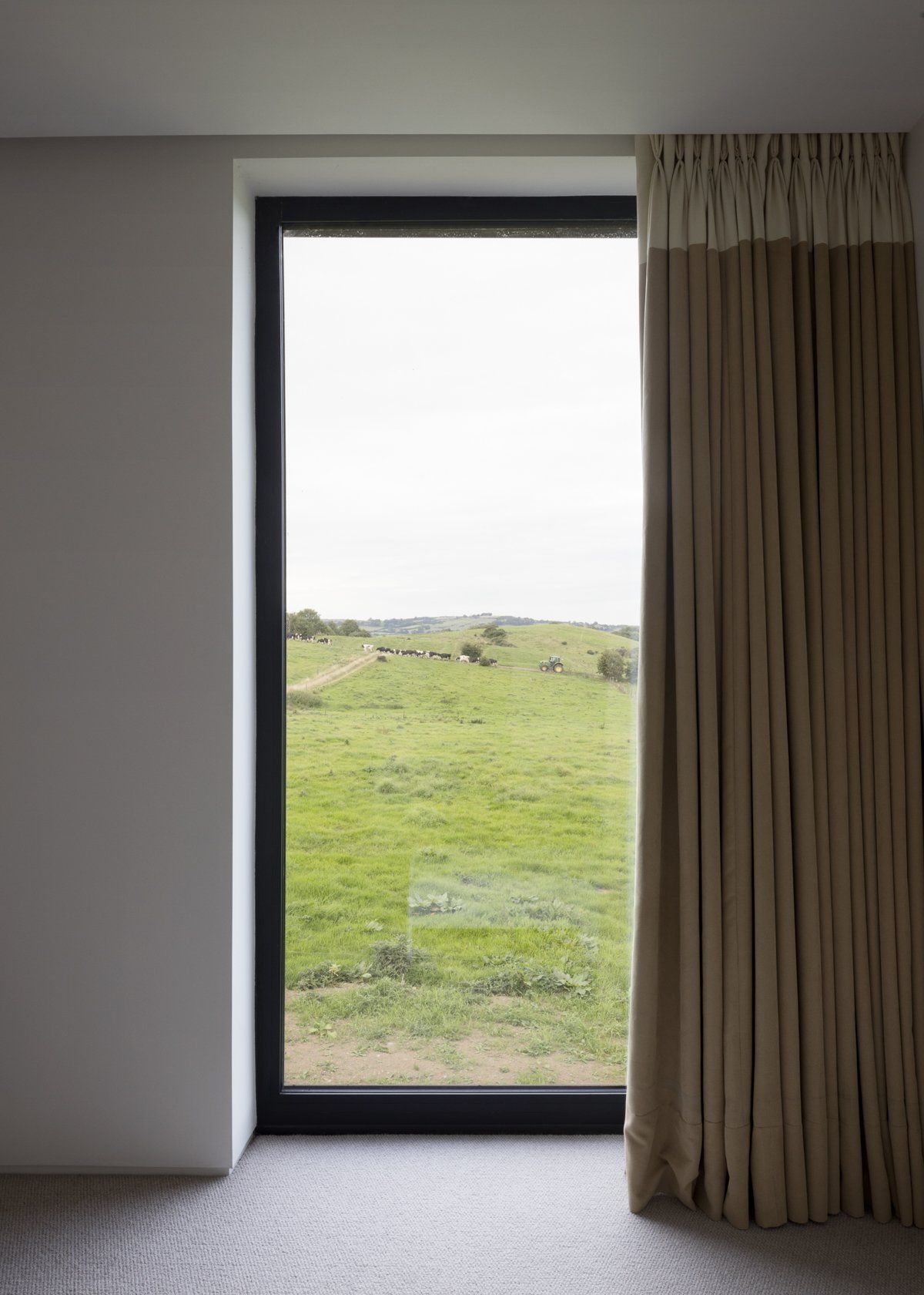 A full length window looking out over green fields