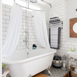 bathroom with white tiles on wall and white bathtub