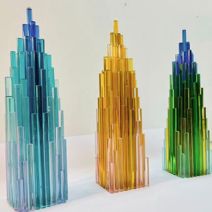 Three Yinka Ilori glass trophies in blue, yellow and green/blue