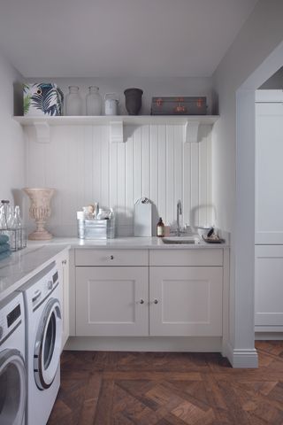 An open plan utility room leading into a kitchen.