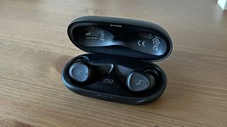 Sennheiser TV clear earbuds with case on wooden surface