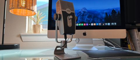 An AKG Lyra on a desk in front of an iMac