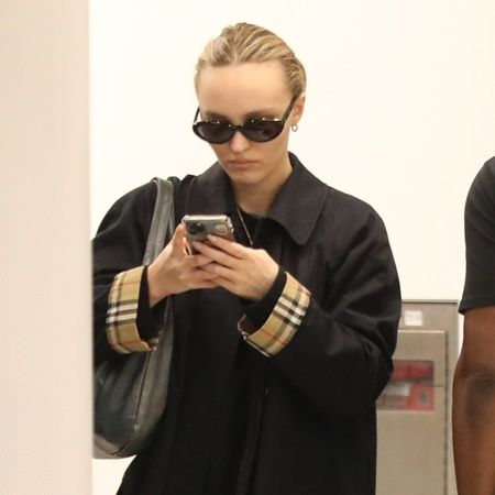 Lily-Rose Depp wears loafers and a car coat.