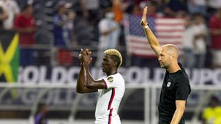 USA's forward Gyasi Zardes (L) and head coach Gregg Berhalter (R) acknowledge fans as they celebrate after beating Jamaica 1-0 following the Concacaf Gold Cup quarterfinal football match between USA and Jamaica at the AT&T stadium in Arlington, Texas on July 25, 2021. 