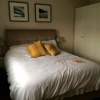 bedroom with frames on wall and pillows on bed