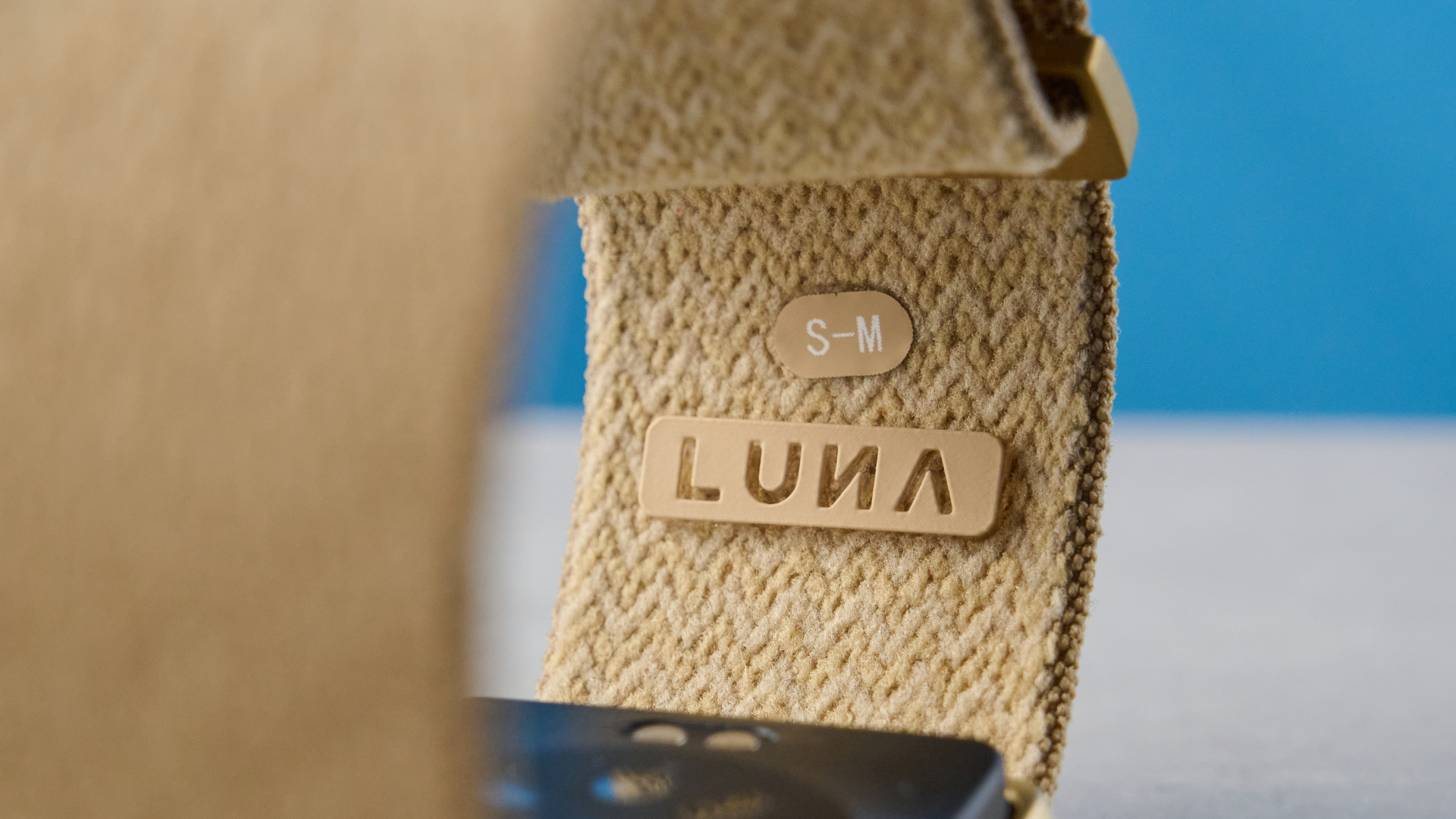 the luna band in beige photographed with the blue tom's guide background being worn by the author