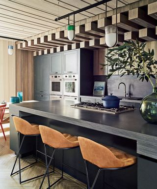 Wood kitchen with panel ceiling, black island and pendants