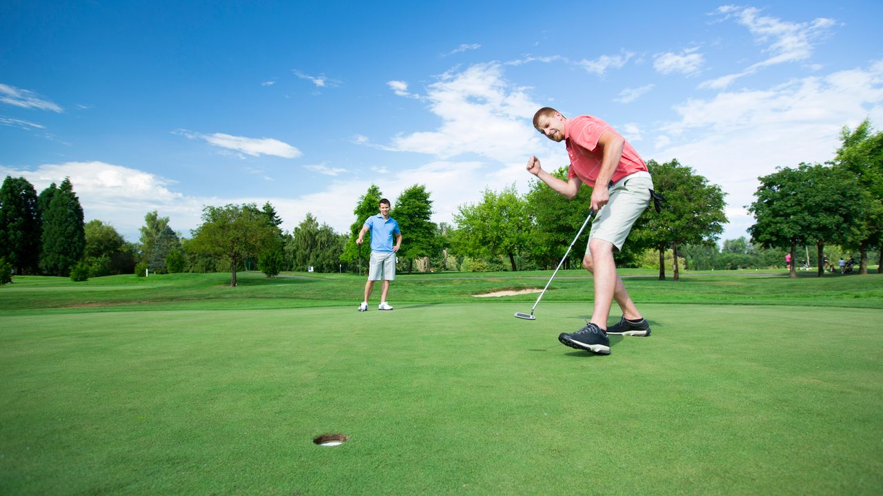 Golfer celebrates a putt going in