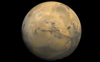 A view of Mars from space showing a large canyon crossing the width of the planet