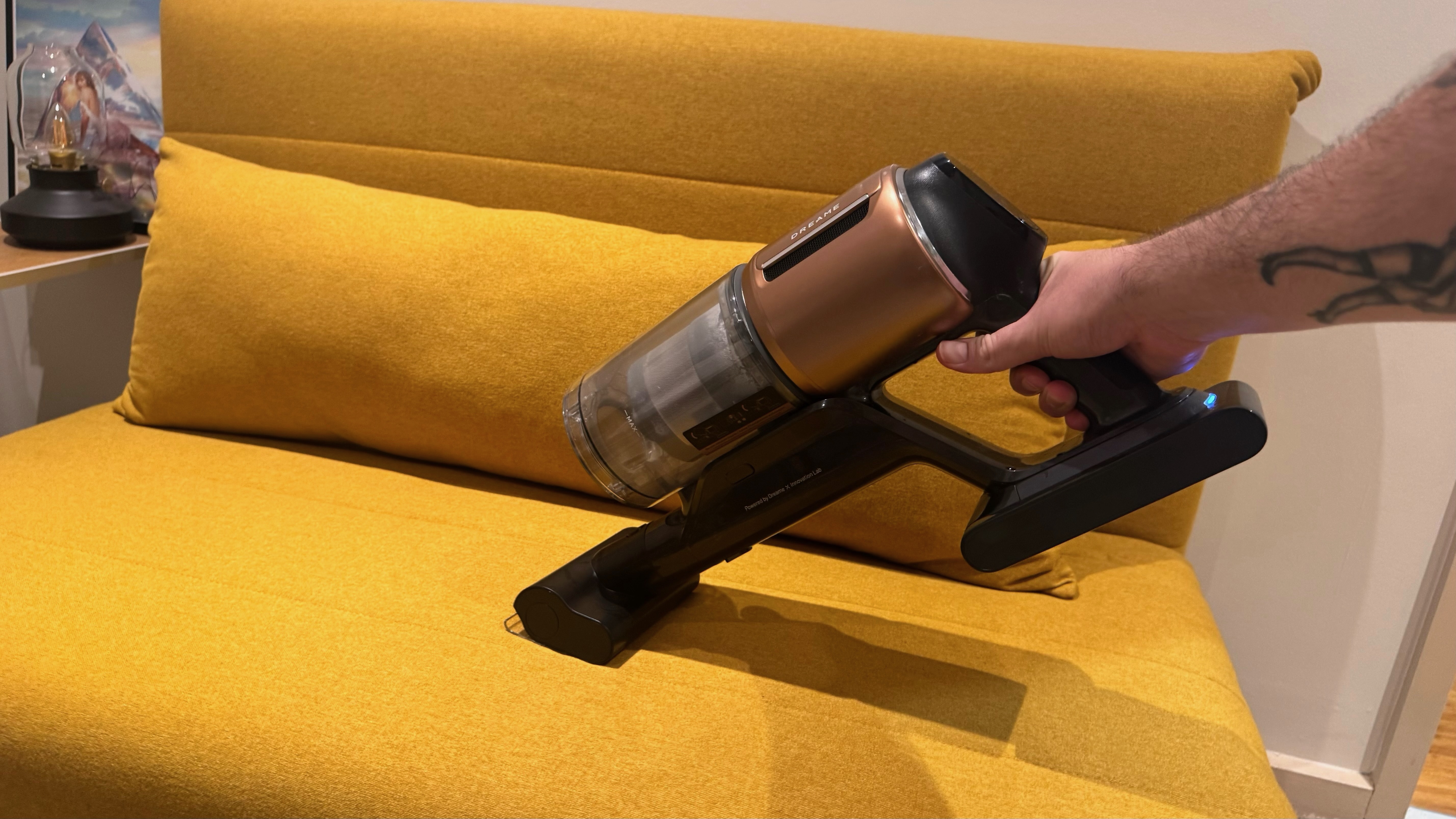 Dreame Z20 being used on a yellow sofa in handheld mode.