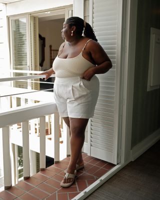 Woman wears cream top, white shorts and flip flops