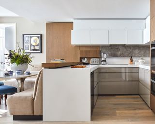 A U-shaped kitchen with a peninsula next to a built-in dining area