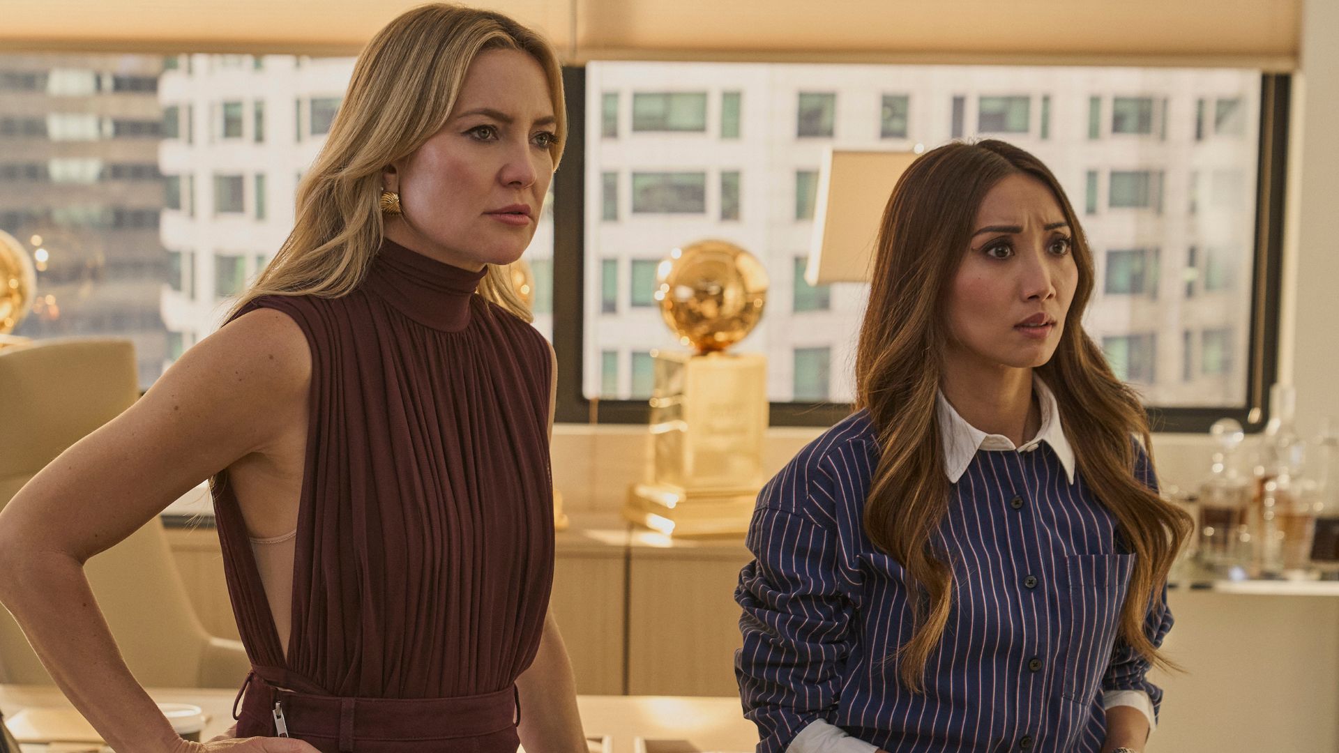 Kate Hudson and Brenda Song look at something off screen.